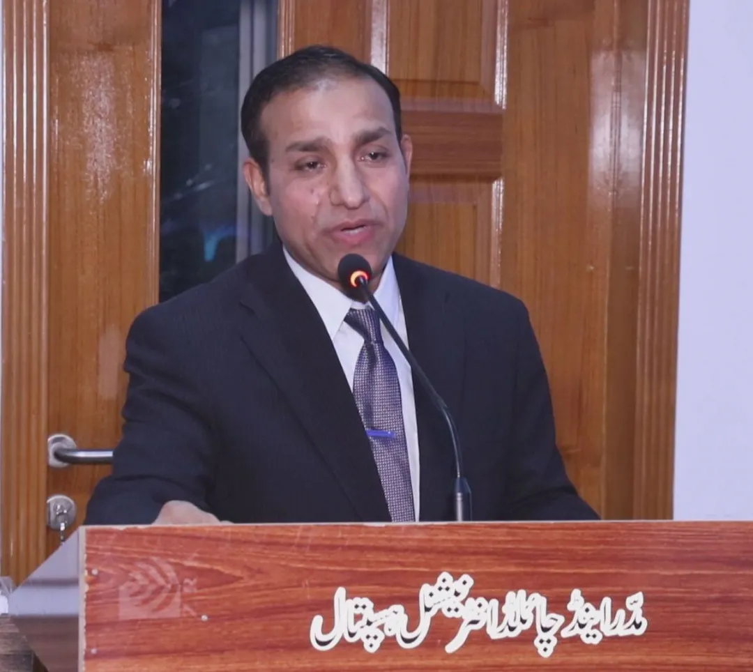 Dr Ejaz Anjum speaking at a lectern at Mother and Child International Hospital